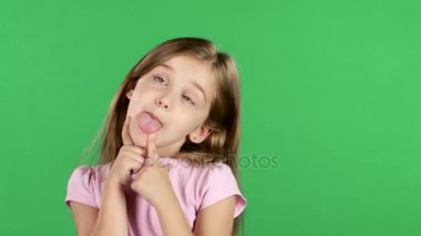 Çocuk dalga geçiyor, dili gösterir ve neşeli palyaçoluk karşı karşıyadır. Yeşil ekran