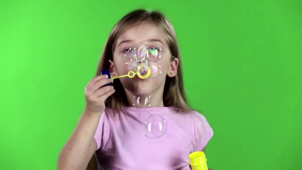 Dítě nechá mýdlové bubliny. Zelená obrazovka. Zpomalený pohyb — Stock video
