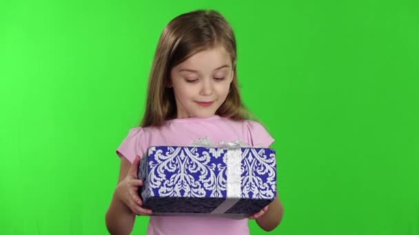 Kind houdt een cadeau in zijn handen. Groen scherm. Slow motion — Stockvideo