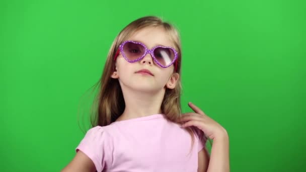 Niña posando para cámaras de video con gafas. Pantalla verde. Movimiento lento — Vídeo de stock