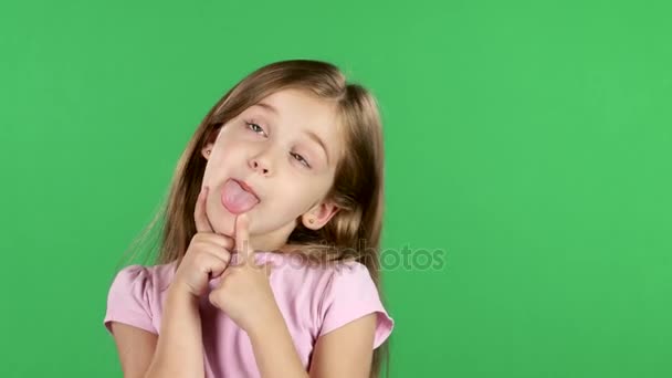 Enfant taquine, montre le langage et les visages joyeux grimaces. Écran vert — Video