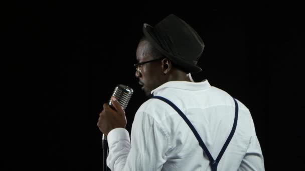 Musicien afro-américain mâle la vue du dos chantant dans un studio d'enregistrement. Fond noir. Gros plan — Video