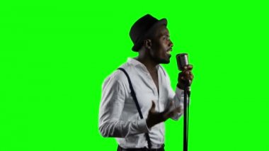 Ciro yarısı erkek şarkıcı şarkı söylüyor bir mikrofon ve dans içine. Yeşil ekran. Yakın çekim