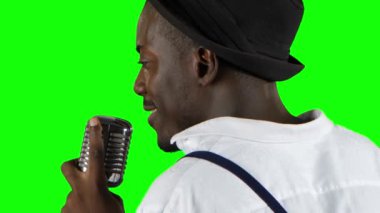 Şarkıcı onun mikrofon tutan ve gesticulating arka görünümünden söylüyor eller. Yeşil ekran. Yakın çekim