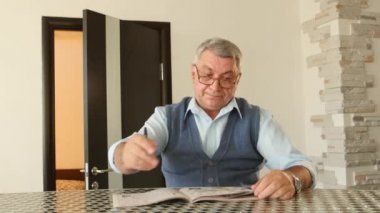 Adam çapraz bulmaca unravels, o zavallı görme yeteneği var ve gözlük takıyor