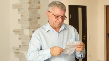 Gri saçlı adam talimat zavallı gözlerini okur.