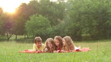 Çok güzel çocuklar birlikte bir çim üzerine bir kitap okuma yaz güzel öğleden sonra. Ağır çekim