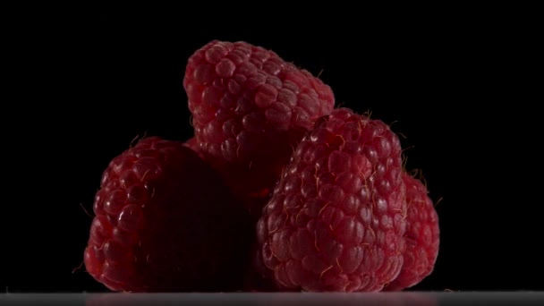 Fruit van raspberry kleur donkerrood draaien op zwarte achtergrond. Close-up — Stockvideo