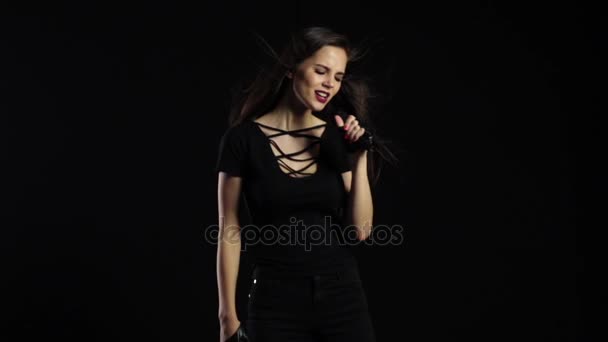 Sängerin tanzt und singt bei einem Konzert in einem Mikrofon. schwarzer Hintergrund. Zeitlupe — Stockvideo