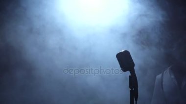 Afro-Amerikan karanlık bir kayıt stüdyosu mikrofon şarkı geliyor. Siyah arka plan. Siluet. Ağır çekim. Yakın çekim