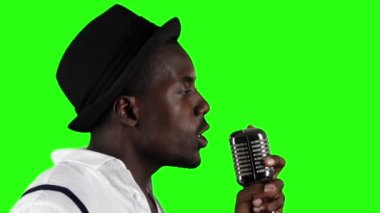 Retro bir mikrofon ve yanında dans içine ciro gesticulating yarısı şarkıcı söylüyor. Yeşil ekran. Ağır çekim. Yakın çekim