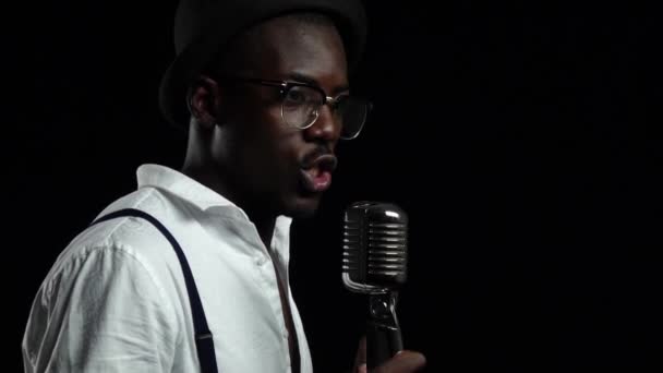 Musicien afro-américain mâle chantant dans un studio d'enregistrement. Fond noir. Au ralenti. Gros plan — Video
