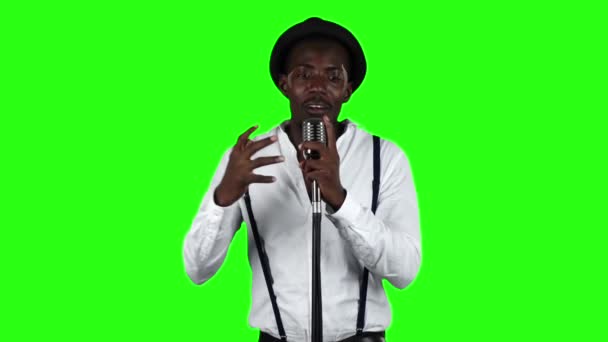 Τραγουδιστής τραγουδά σε ένα ρετρό μικρόφωνο νηματουργίας και χορό γύρω από αυτόν. Πράσινη οθόνη. Αργή κίνηση — Αρχείο Βίντεο