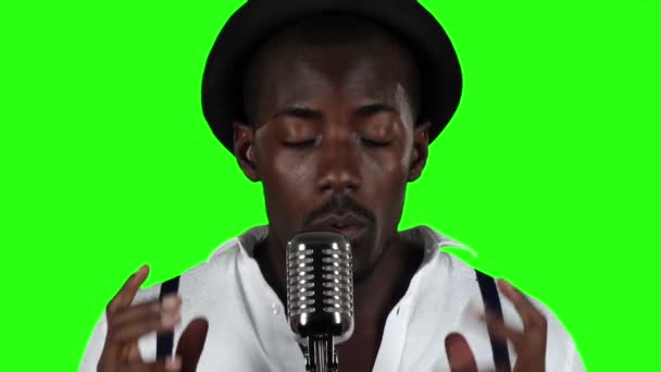Killen med mustasch och skägg sjunger i en retro mikrofon. Grön skärm. Slow motion. Närbild — Stockvideo