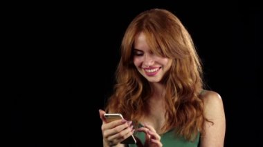 Kız ona telefon fotoğraf bakar. Siyah arka plan. Ağır çekim