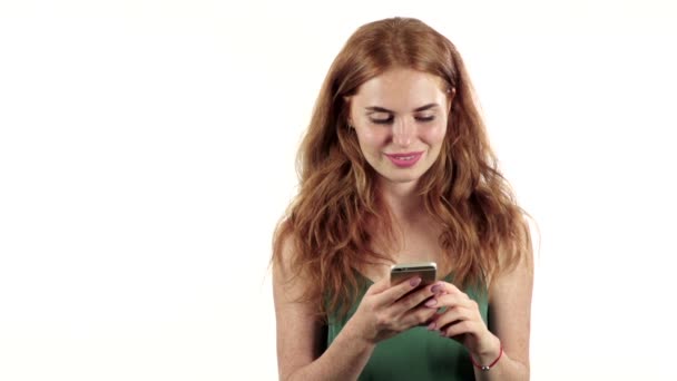 Meisje kijkt naar de foto op haar telefoon. Witte achtergrond. Slow motion — Stockvideo