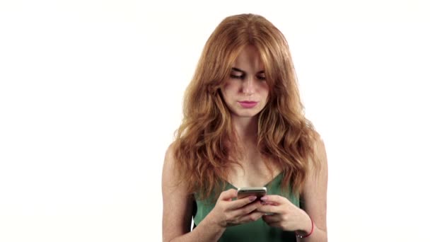 Mädchen betrachtet das Foto auf ihrem Handy. weißer Hintergrund. Zeitlupe — Stockvideo