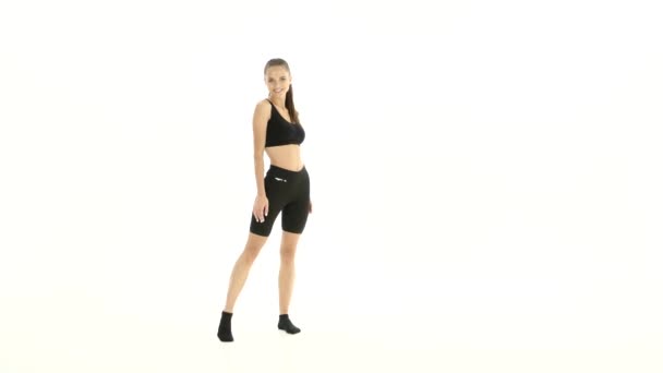 Meisje adverteert kleren en toont een thumbs up. Witte achtergrond — Stockvideo