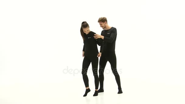 Dziewczyna i chłopak reklamować ubrania i Pokaż kciuk w. Białe tło — Wideo stockowe