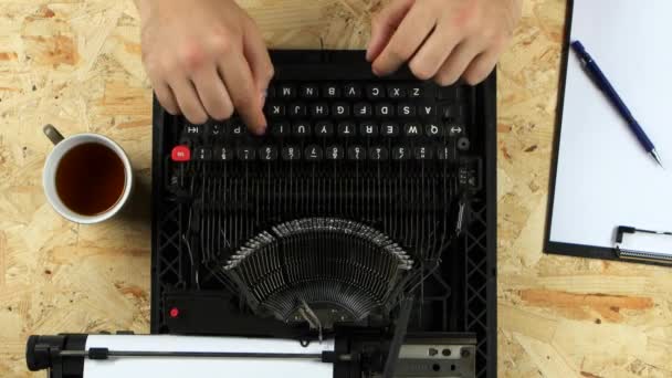 Escritor escribiendo texto en una máquina de escribir lanza una hoja. Vista desde arriba — Vídeos de Stock