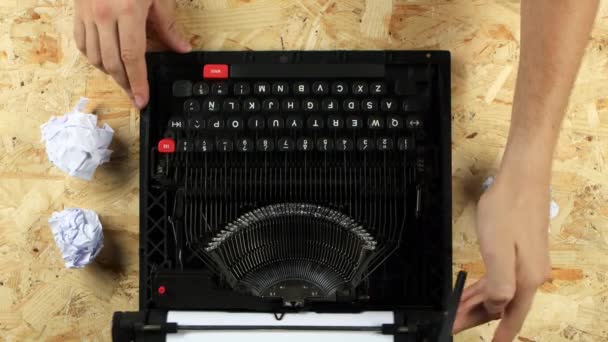 Escritor digitando texto em uma máquina de escrever joga fora uma folha. Vista de cima — Vídeo de Stock