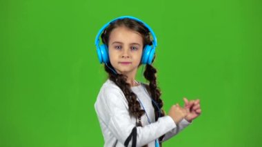 Bebek kulaklık müzik dinliyor. Yeşil ekran. Ağır çekim