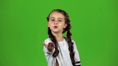Çocuk bir hava öpücük gönderir. Yeşil ekran. Ağır çekim