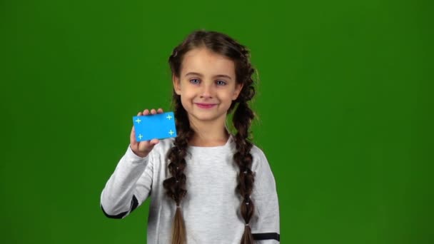Dítě ukazuje prázdnou kartu. Zelená obrazovka. Zpomalený pohyb — Stock video