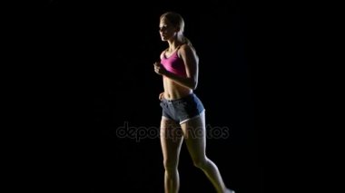Siyah bir arka plan üzerine açık görünüm çalışan spor fitness kadın. Siluet