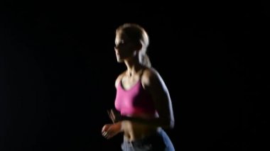 Uzun saçlı kız güvenle siyah bir arka plan üzerinde çalışır. Yakın çekim