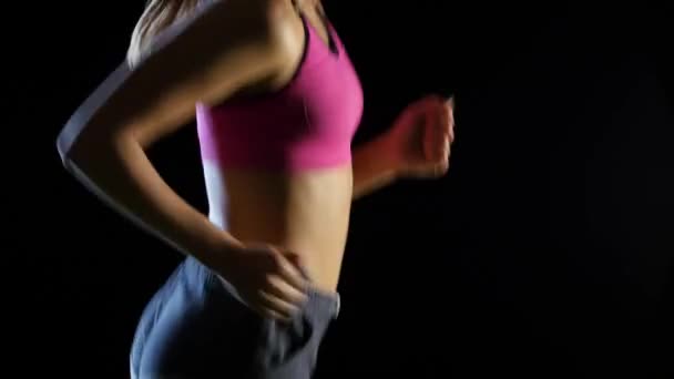 Жінка-спортсменка біжить на чорному тлі збоку. крупним планом — стокове відео