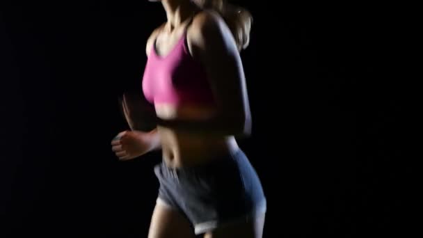 Nő a rövidnadrág és top gyönyörűen fut egy fekete képernyő. Közelről — Stock videók