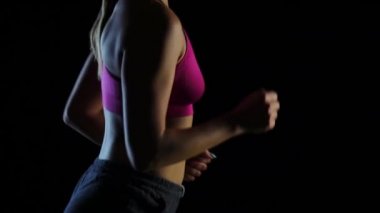 Siyah bir ekranda çalışan bir kız figürü tarafında dan görüntüleyin. Ağır çekim. Yakın çekim