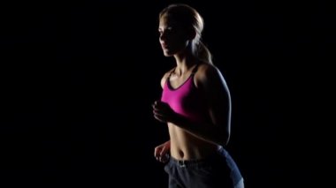 Harika kız siyah bir arka plan üzerinde çalışıyor. Ağır çekim