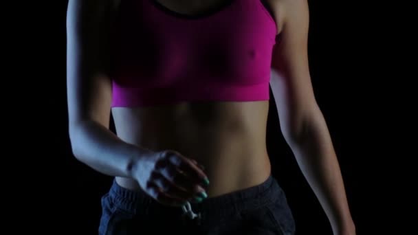 Vrouw sexy wandelingen in de sport dragen op zwarte achtergrond. Silhouet. Slow-motion. Close-up — Stockvideo