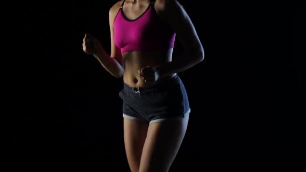 Meisje in de sport draait op een zwarte achtergrond. Slow-motion. Close-up — Stockvideo