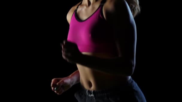 Sportler läuft in kurzen Hosen und T-Shirt vor schwarzem Hintergrund. Zeitlupe. Nahaufnahme — Stockvideo