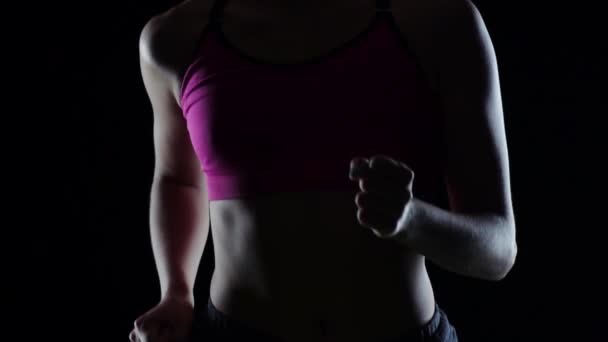 Fitness athlete jogger on a black background. Silhouette. Slow motion. Close up — Stock Video