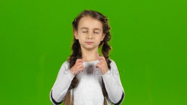 Çocuk parmaklarını onun kollarında haçlar. Yeşil ekran