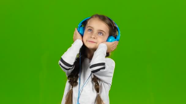 Baby im Kopfhörer hört Musik. Green Screen — Stockvideo