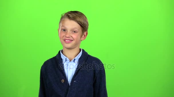 Niño coquetea y guiña. Pantalla verde. Movimiento lento — Vídeo de stock