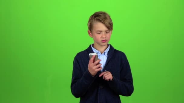 Jongen is op de telefoon. Groen scherm. Slow motion — Stockvideo