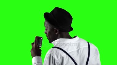 Adam Afrikalı-Amerikalı profesyonel bir kayıt stüdyosunda şarkı mikrofon arkada görünümden. Yeşil ekran. Ağır çekim. Yakın çekim