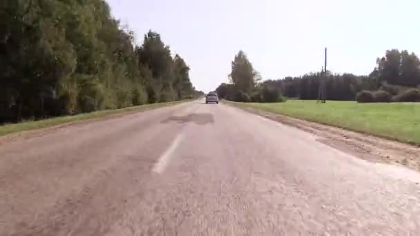 Χώρα ασφαλτοστρωμένο αυτοκινητόδρομο κατά μήκος του δάσους — Αρχείο Βίντεο