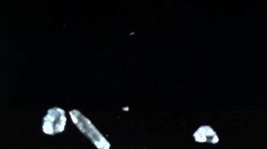 Karanlık bir odada yere düşen elmas, onlar parlak twinkle. Siyah arka plan. Ağır çekim