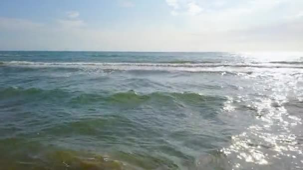 El mar fluctuante brilla en la luz del sol contra el cielo con nubes. Encuesta aérea — Vídeo de stock