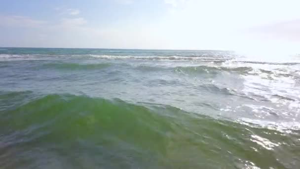 Las torcidas olas se acercan a la costa del mar dejando huellas húmedas en la arena. Encuesta aérea — Vídeo de stock