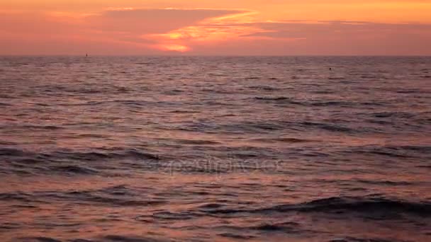 Havet under gömmer sig bakom molnen solen i solnedgången — Stockvideo