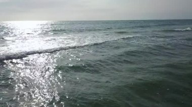 Güneşten gelen deniz suyu bulutsuz bir gökyüzü altında pırıl pırıl. Hava anket. Ağır çekim