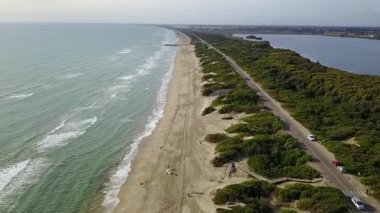 Havadan görünümü deniz plaj yol ağaçlar ve su alanları mavi gökyüzünün altında. Ağır çekim